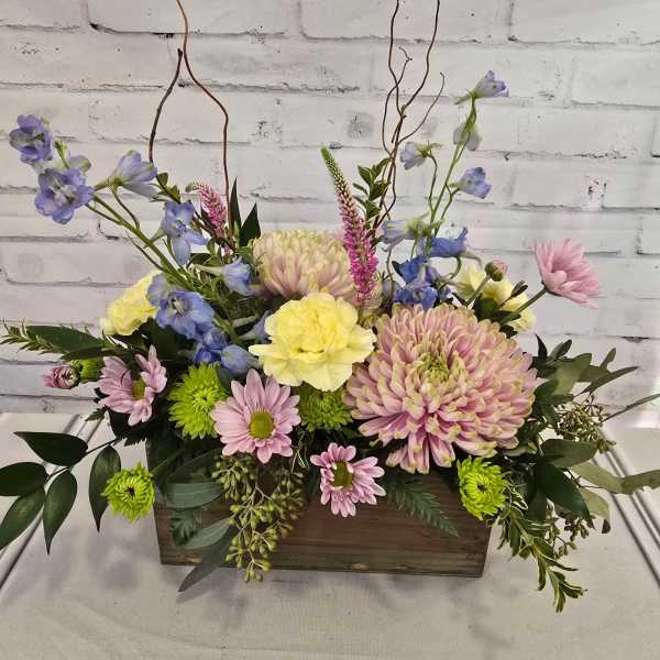 Mixed pastel flower arrangement in a wooden box
