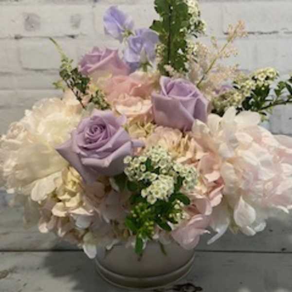 Pastel bouquet of roses and hydrangeas in a round vase