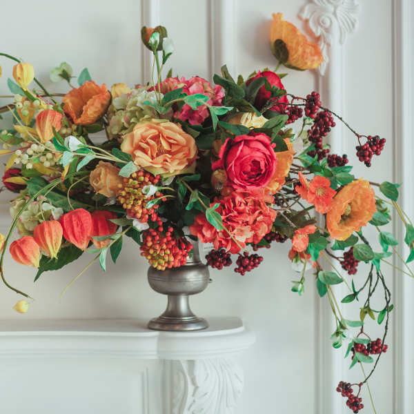 Arrangement of orange and pink flowers in a silver vase