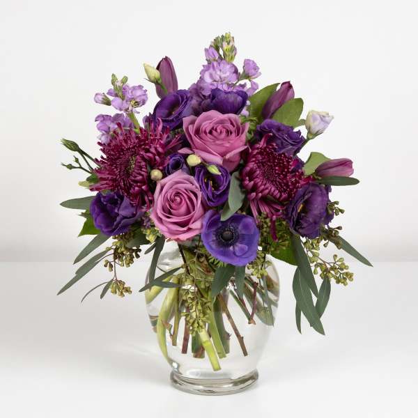 Purple and pink bouquet in a clear glass vase