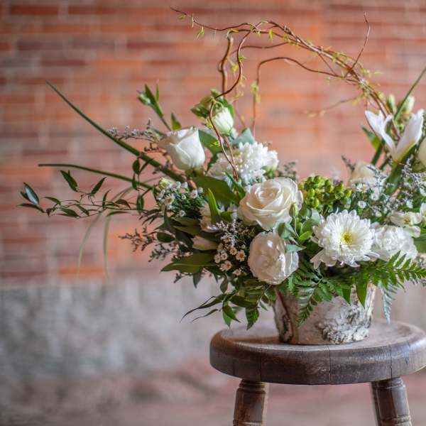 White floral arrangement in a rustic metal container