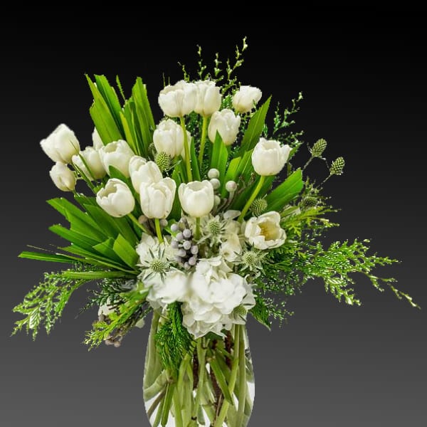White tulips and hydrangeas in a clear glass vase