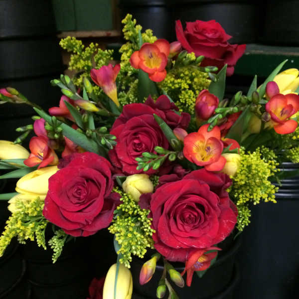 Bouquet of red roses with yellow and orange freesia