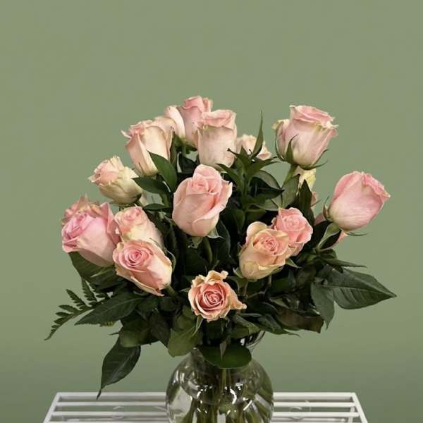 Pink roses arranged in a clear glass vase