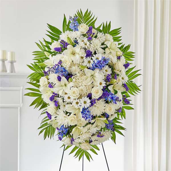 Large white and purple funeral spray on an easel
