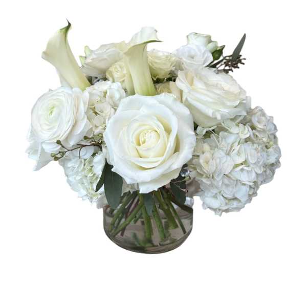 White roses and calla lilies arranged in a glass vase