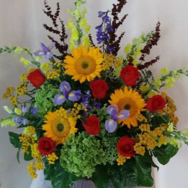 Colorful mixed flower arrangement with sunflowers and red roses