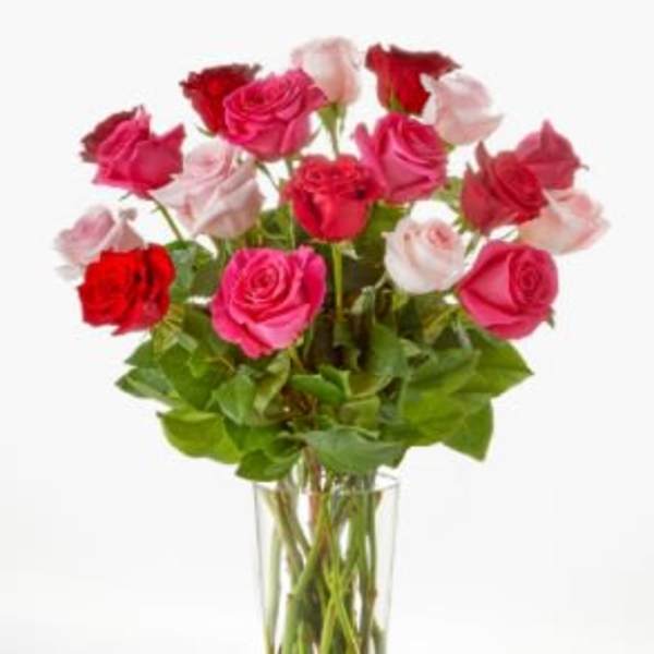 Tall bouquet of red and pink roses arranged in a clear glass vase