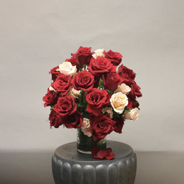 Bouquet of red and cream roses in a glass vase