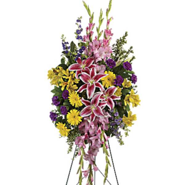 Standing funeral spray with pink lilies, yellow daisies, and purple flowers