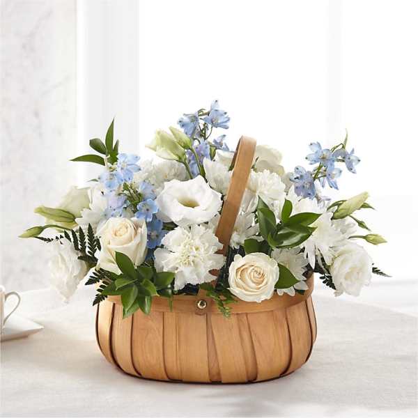 White and blue floral arrangement in a wooden basket