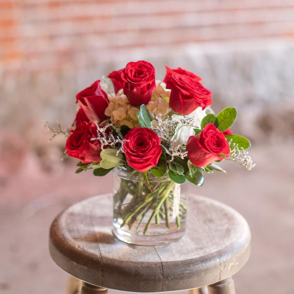 Red roses arranged in a clear glass vase