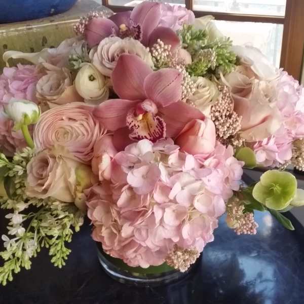 Pink and cream floral arrangement in a glass vase