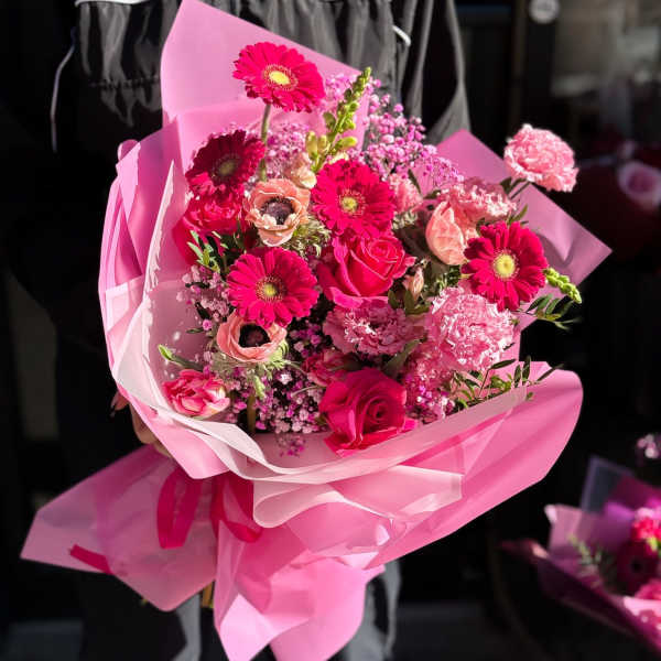 Pink bouquet with roses and gerbera daisies wrapped in pink paper