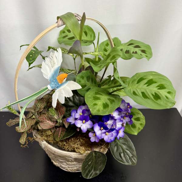 Basket planter with green foliage, purple flowers, and a decorative bird