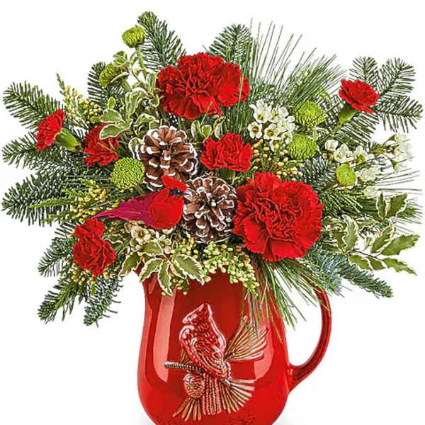 Red carnations and pinecones arranged in a red pitcher vase