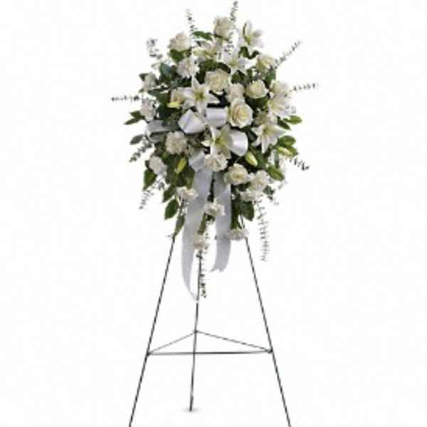 White floral standing spray on an easel with ribbon streamers