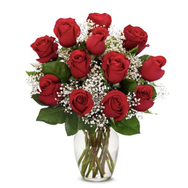 Red roses arranged in a clear glass vase with baby's breath