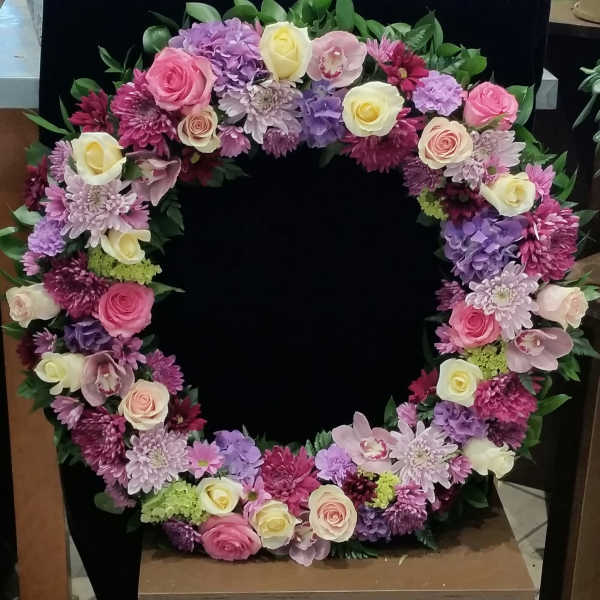 Heart-shaped floral wreath with pink, purple, and white blooms
