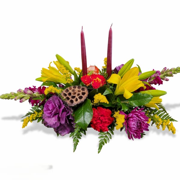 Colorful floral centerpiece with two tall burgundy candles