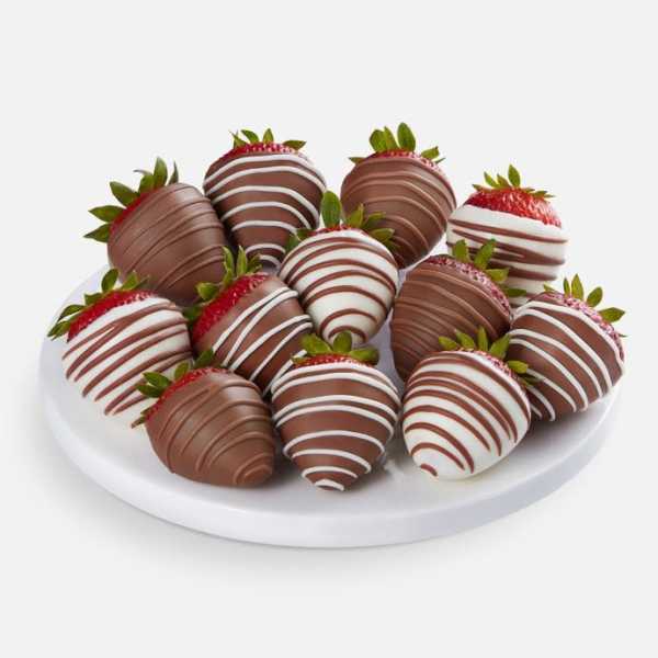 Plate of chocolate-covered strawberries with white drizzle
