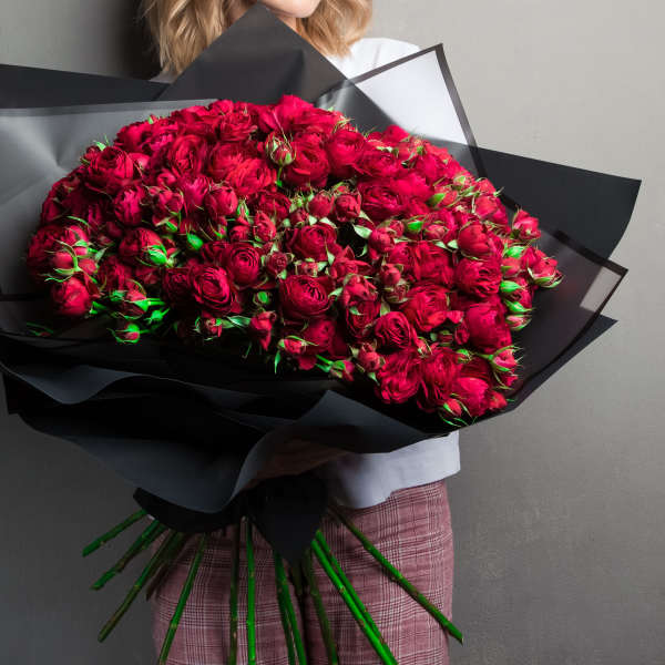 Large bouquet of deep red roses wrapped in black paper