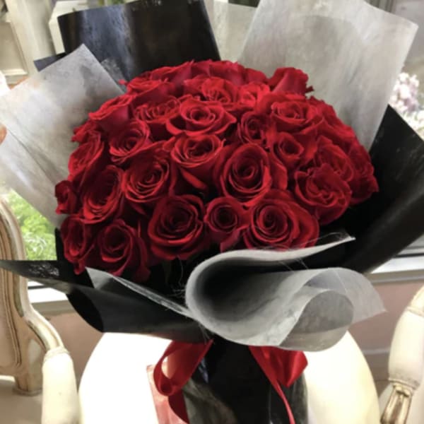 Bouquet of red roses wrapped in black and silver paper