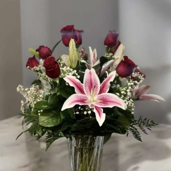 Pink lilies and red roses in a clear glass vase