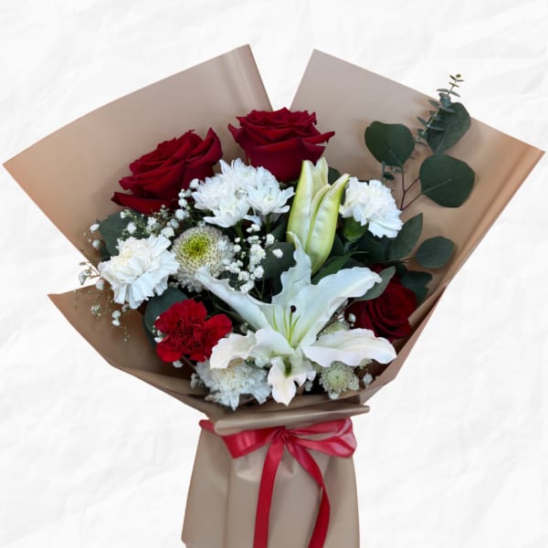 Bouquet of red roses and white lilies wrapped in tan paper