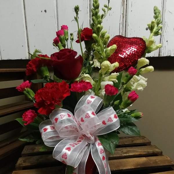 Red roses and carnations with a heart-patterned ribbon bow