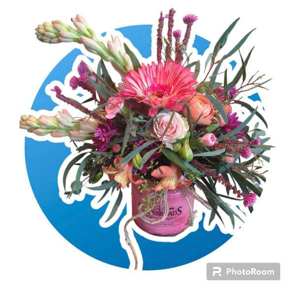 Bright pink and peach mixed flower arrangement in a pink jar-style vase