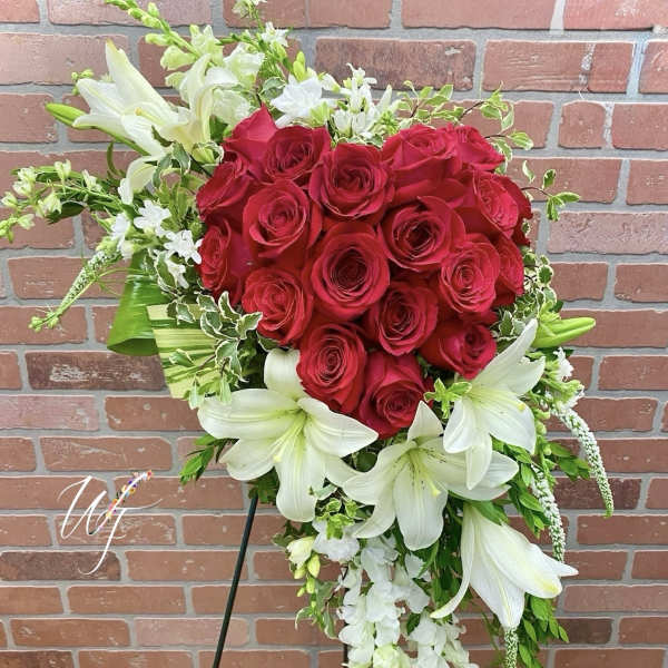 Heart-shaped bouquet of red roses and white lilies on a stand