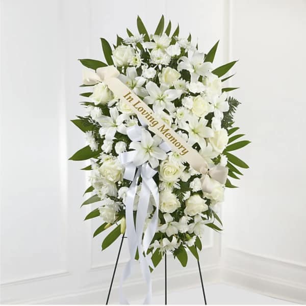 White sympathy wreath with ribbon on a stand