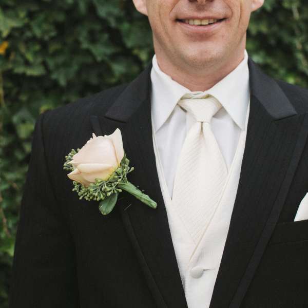 Man in a suit wearing a pale rose boutonniere
