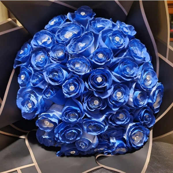 Bouquet of vivid blue roses with jeweled centers wrapped in black paper