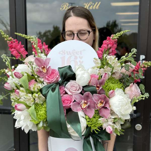 Large pink and white flower arrangement in a white hat box with a ribbon