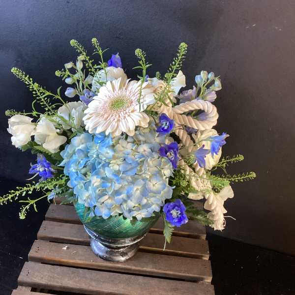 Blue and white floral arrangement in a glass vase