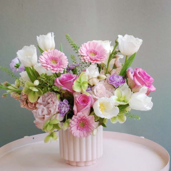 Pink and white mixed flower arrangement in a ribbed vase