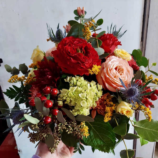 Mixed bouquet with red, peach, and yellow roses and hydrangea