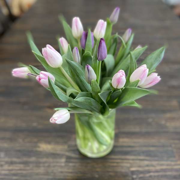 Pink and purple tulips in a clear glass vase