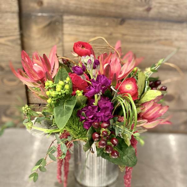 Pink and purple floral arrangement in a metal vase
