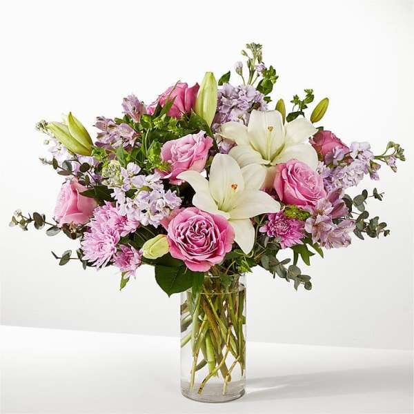 Pink roses and white lilies in a clear glass vase