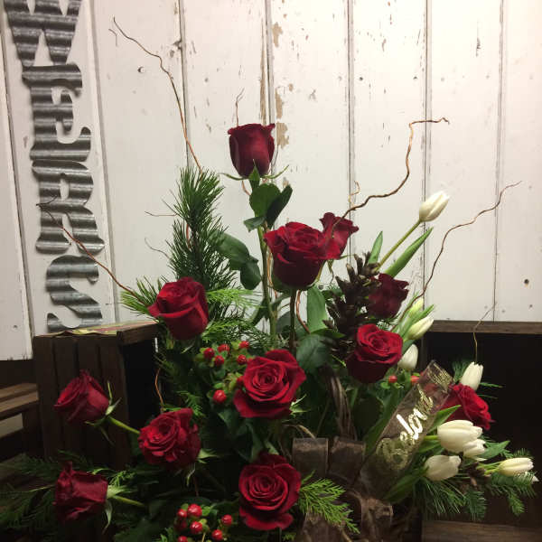 Red roses and white tulips arranged in a rustic basket