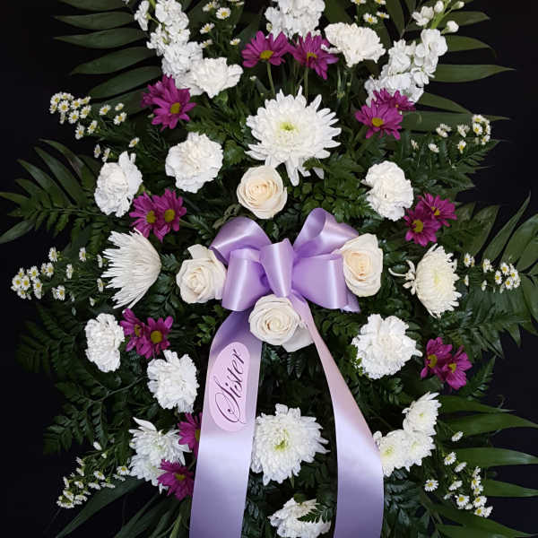 Standing floral spray with white and purple flowers and a lavender ribbon