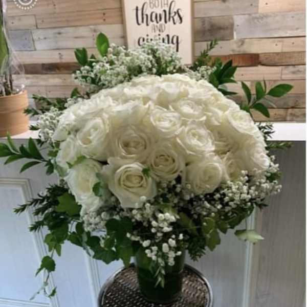White rose bouquet with baby's breath in a glass vase