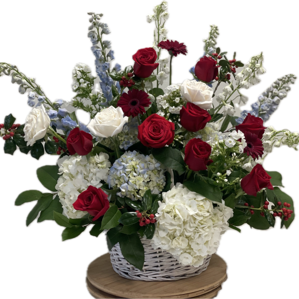 Basket arrangement of red and white roses with blue and white flowers