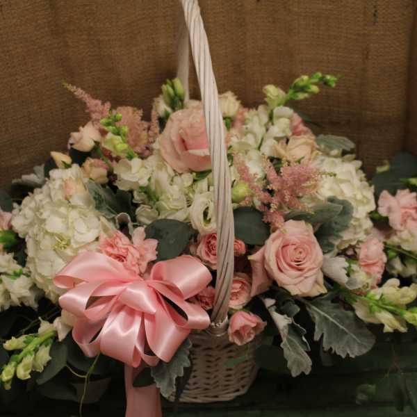 Basket of pink and white flowers with a pink ribbon bow