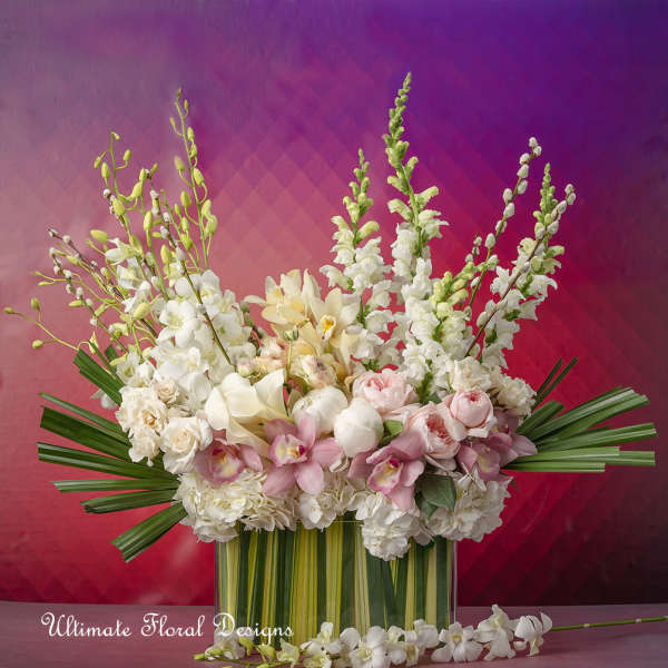 Large white and blush floral arrangement in a striped vase