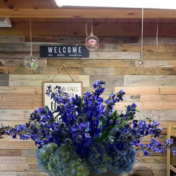 Blue and purple floral arrangement in a round vase