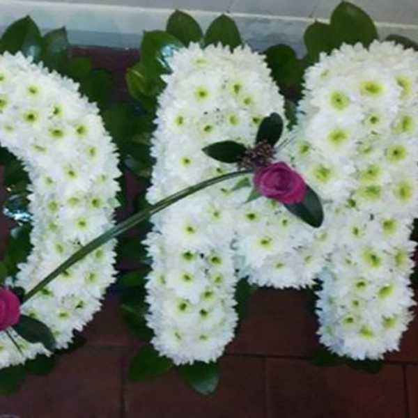 White floral letters spelling MOM with pink roses accenting the design